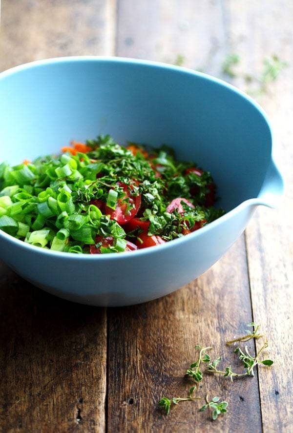 Veggies and herbs in a blue mixing bowl.