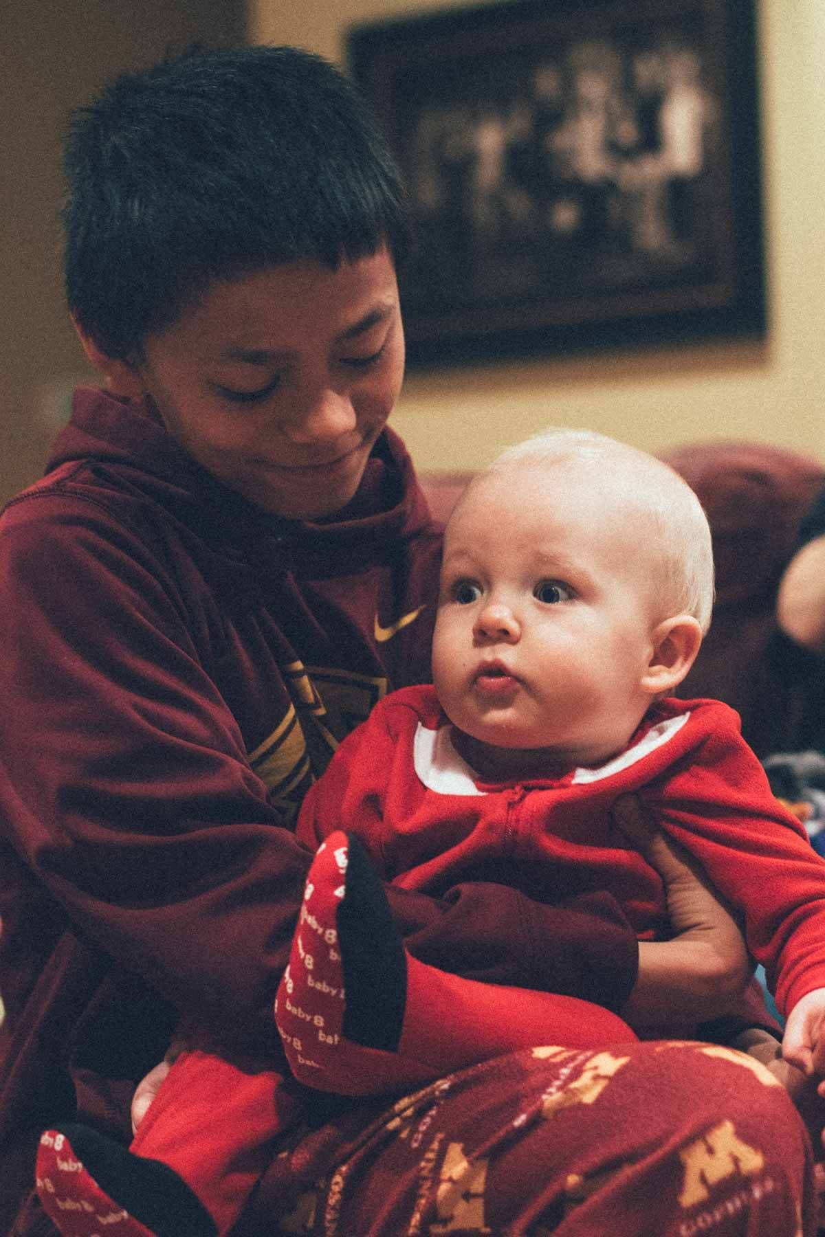 Young boy holding a baby.